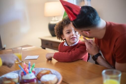 Pai e filho adulto sorrindo e se abraçando em um momento de carinho e celebração de aniversário, simbolizando conexão.