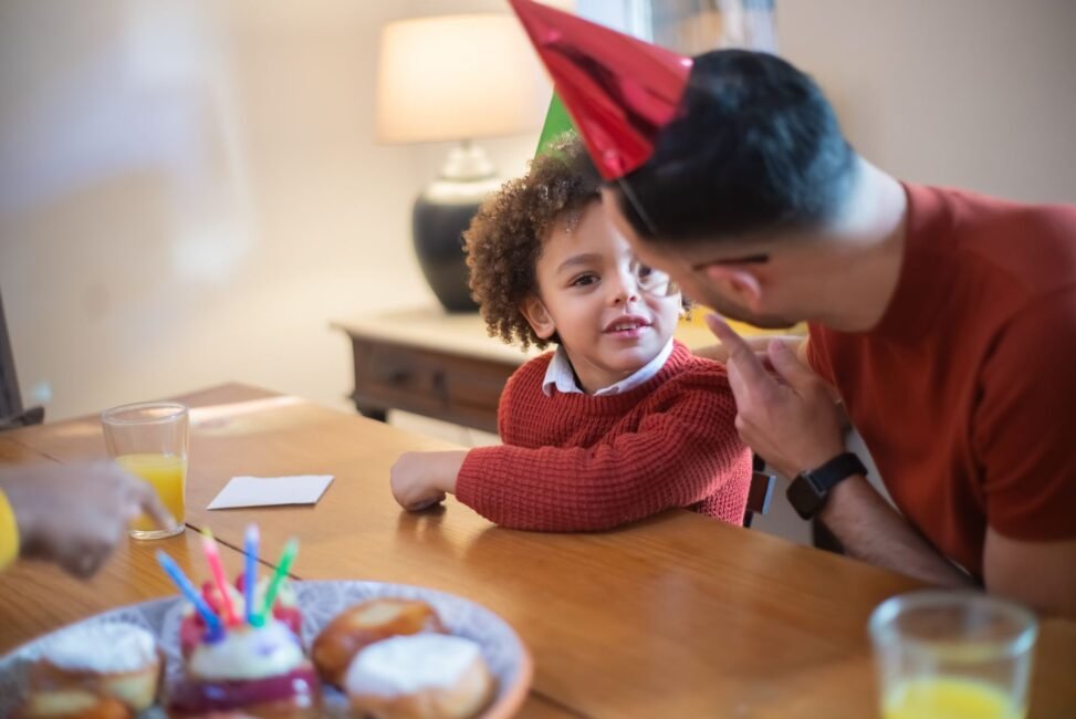 Pai e filho adulto sorrindo e se abraçando em um momento de carinho e celebração de aniversário, simbolizando conexão.